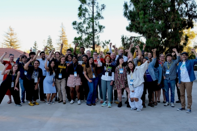 Group photo of SRLC attendees. 30 or so people smile and hold their fists up in solidarity.