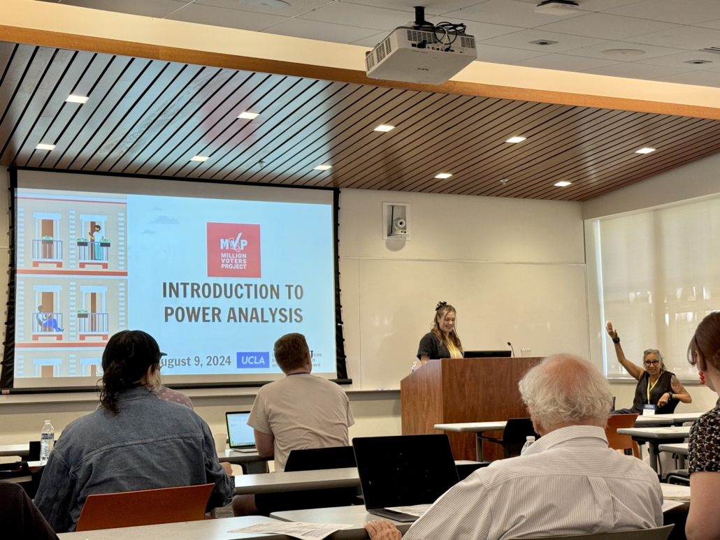 Katie Miles from UC Berkeley Labor Center teaches a workshop in a classroom. She stands in front of a slideshow that reads "Introduction to Power Analysis"