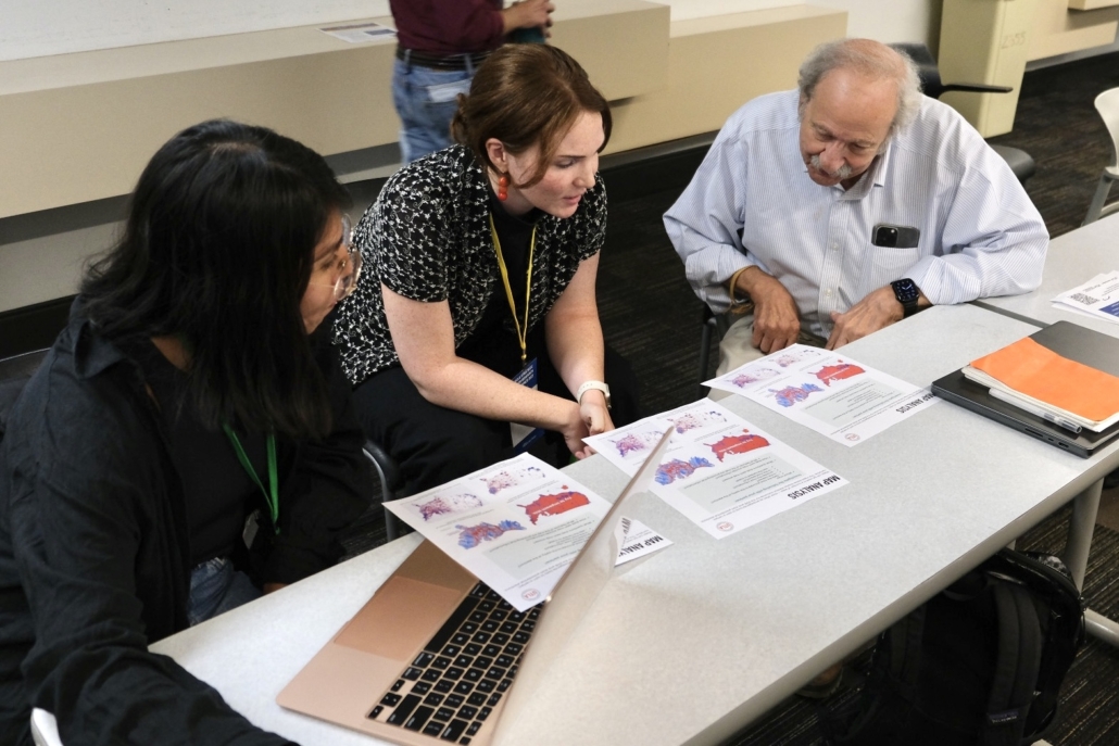 Participants review handouts with maps in the Mapping For Research & Organizing workshop