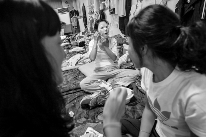 KTX unionist applies a facemask at Seoul Train Station encampment, June 2006 / Chung Taekyong