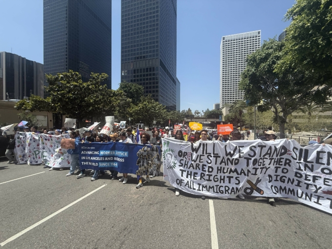 Students hold banners representing the UCLA Labor Center and UCLA Labor Studies, along with other signs promoting immigrant and worker justice / UCLA Labor Studies