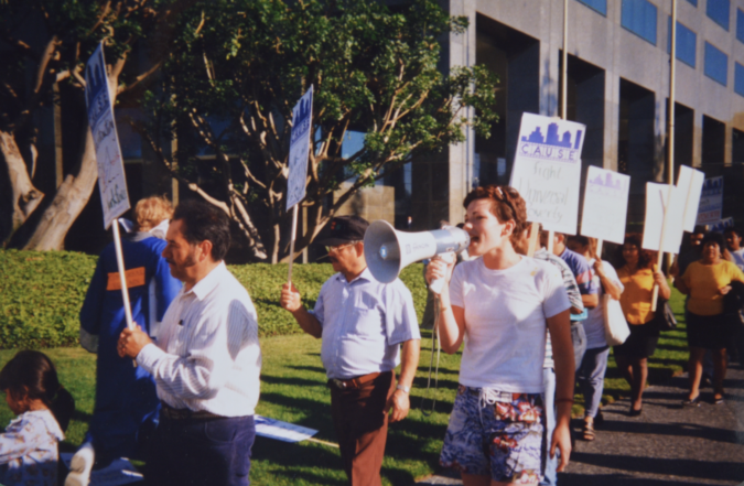 Mae Weston, a UCLA undergraduate student and participant in Union Summer, leads chants at a CAUSE (Coalition for Accountability in the Universal Studios Expansion) picket line at Universal Studios headquarters, 1998 / IRLE Archives 