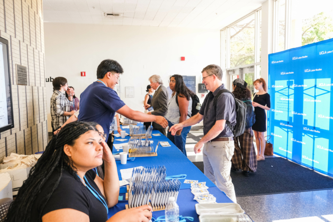 IRLE director Tobias Higbie checks in with a UCLA Labor Studies student volunteer on day 1 of the SLRC / UCLA IRLE